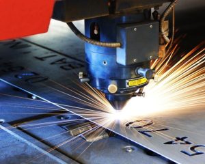 Máy laser hiện đại đang khắc logo và chữ nổi trên mica, phù hợp cho biển quảng cáo và trang trí nội thất

